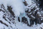 Avalanche descending over Pilsner Pillar ice climbing terrain in the Canadian Rockies